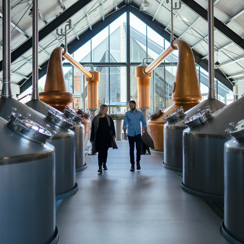 Visitors walking past copper pot stills inside Callington Mill Distillery in Oatlands, Tasmania